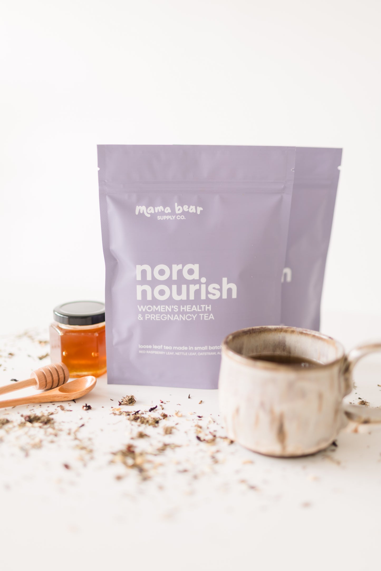 Nora Nourish tea package with a cup and honey on a white background