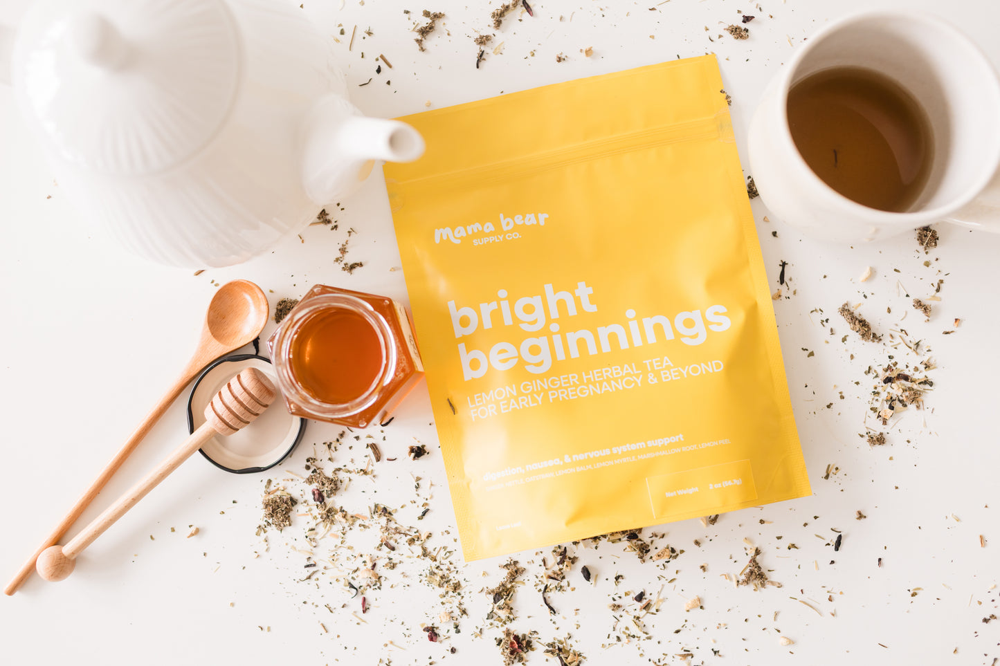 Yellow package labeled 'bright beginnings' with a teacup, honey jar, and tea leaves on a light surface.